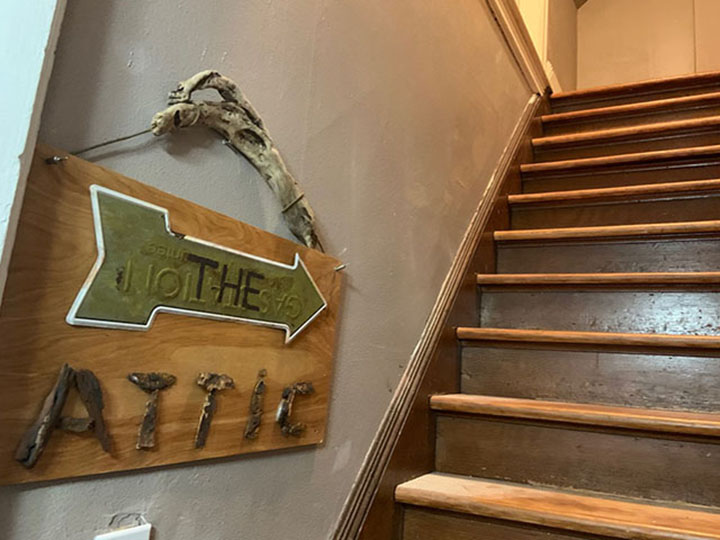 Tacoma Corporate Rental - Sign says "RThe Attic" pointing up a set of wooden stairs